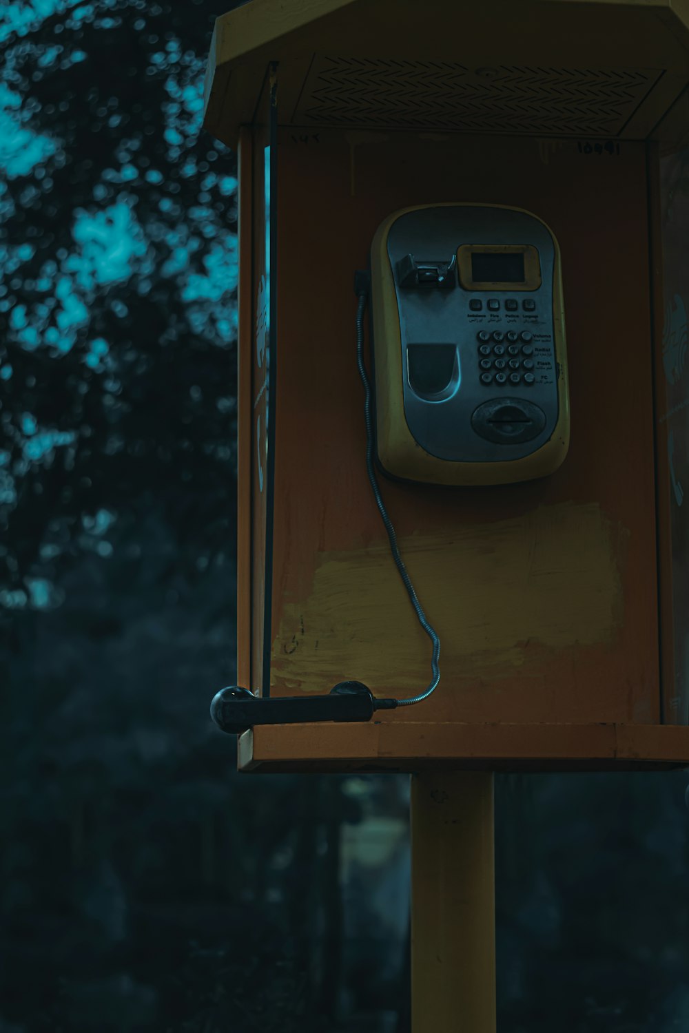 Teléfono gris sobre pared de madera marrón
