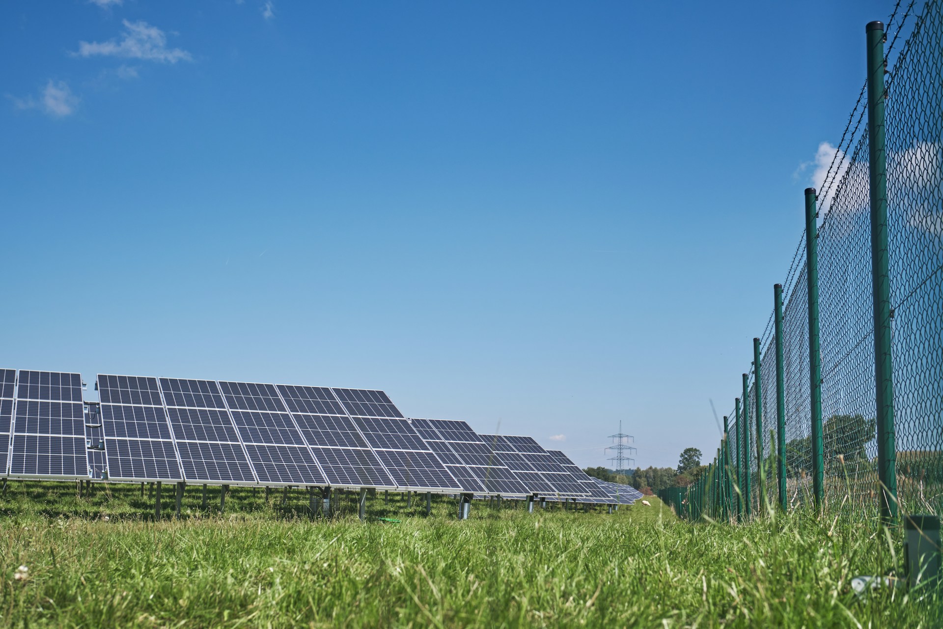 solar panels on green grass field under blue sky during daytime