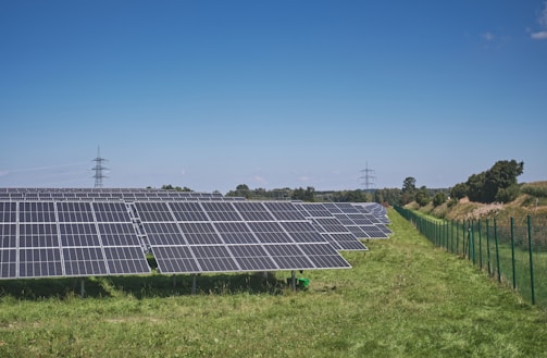 solar panels on green grass field under blue sky during daytime