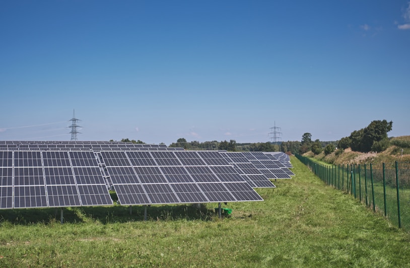 solar panels on green grass field under blue sky during daytime
