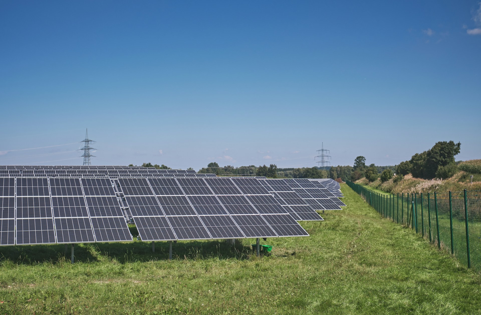 solar panels on green grass field under blue sky during daytime
