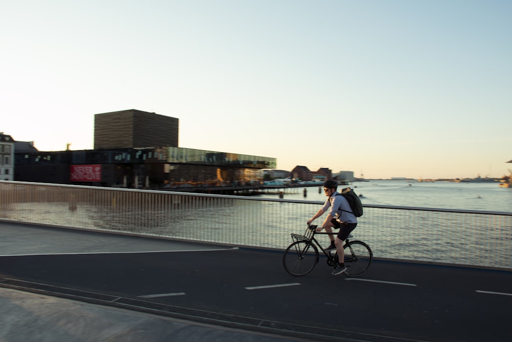 man in black shirt riding bicycle on road during daytime