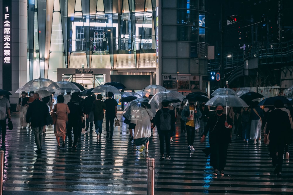 people walking on sidewalk with umbrella during rain