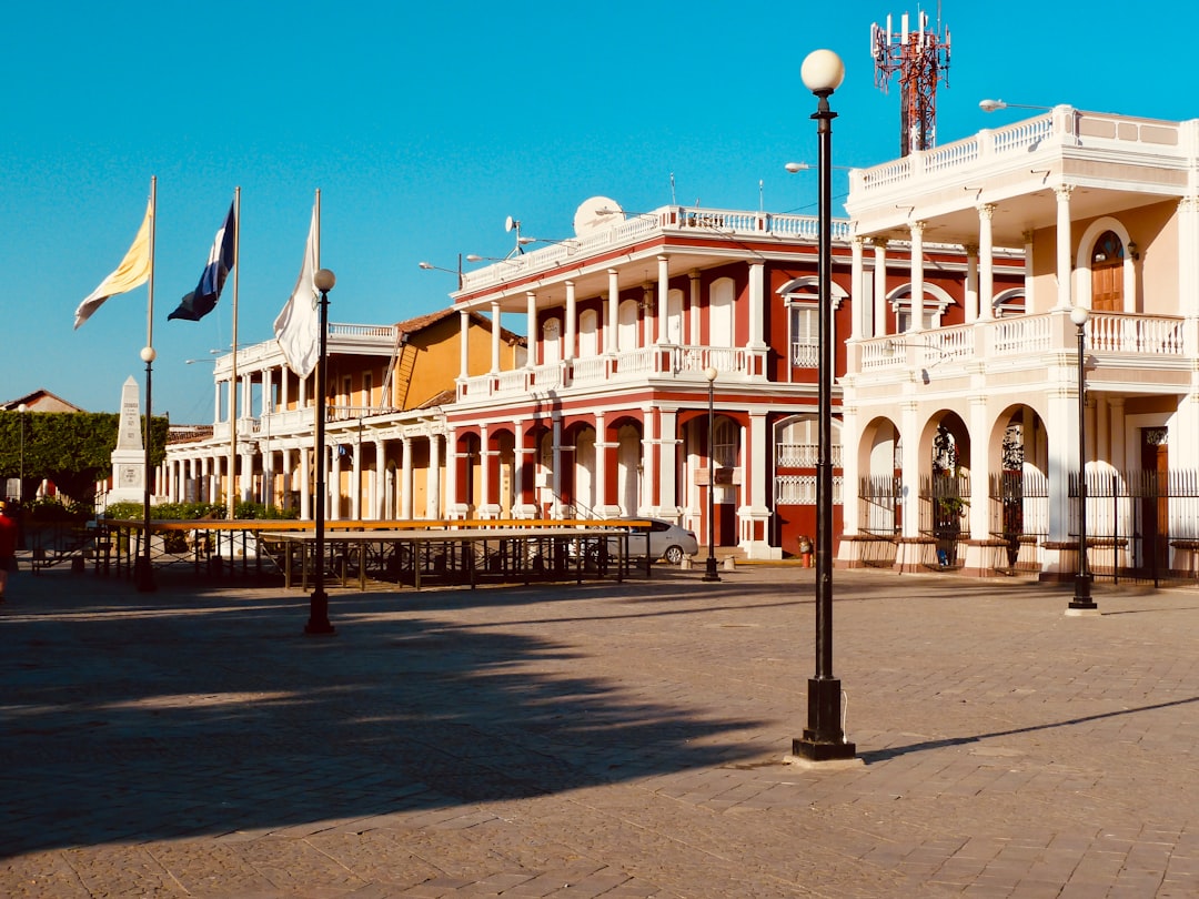 white concrete building with flags on top during daytime