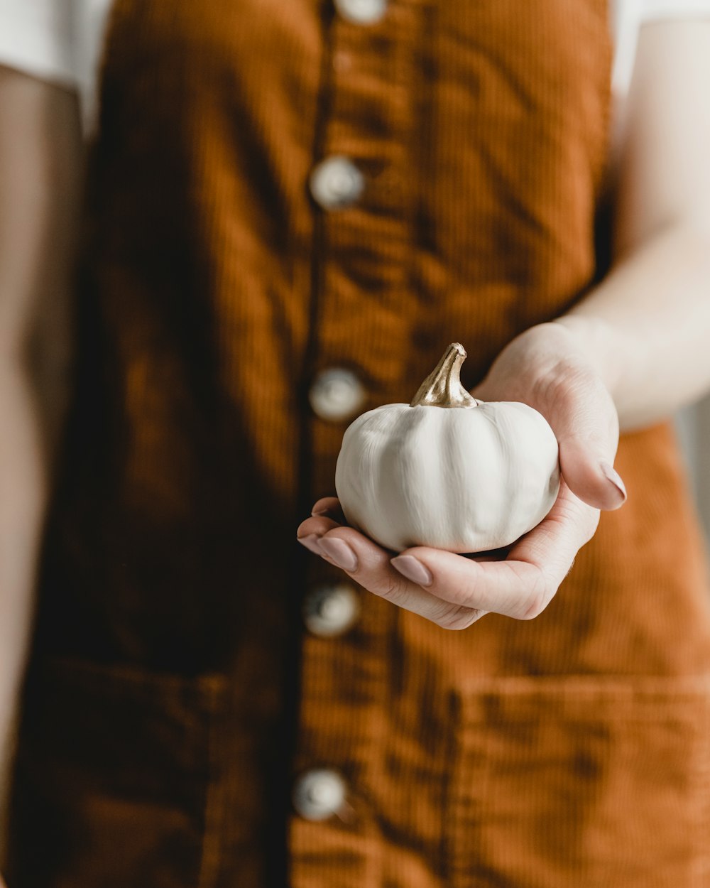 person holding white ceramic heart ornament