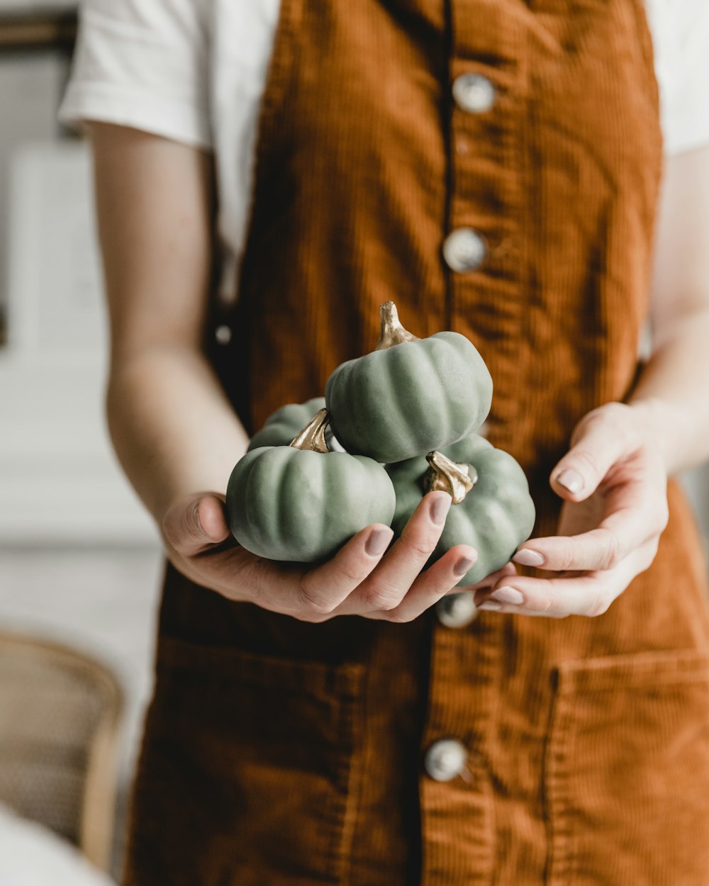 person holding green fruit in tilt shift lens