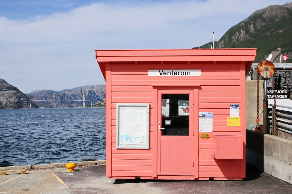 red and white wooden house near body of water during daytime