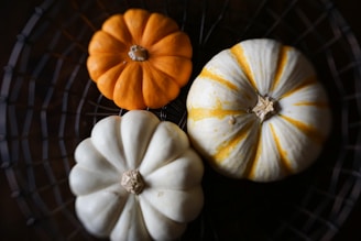 white and orange pumpkins on black metal grill