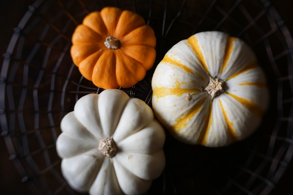 white and orange pumpkins on black metal grill