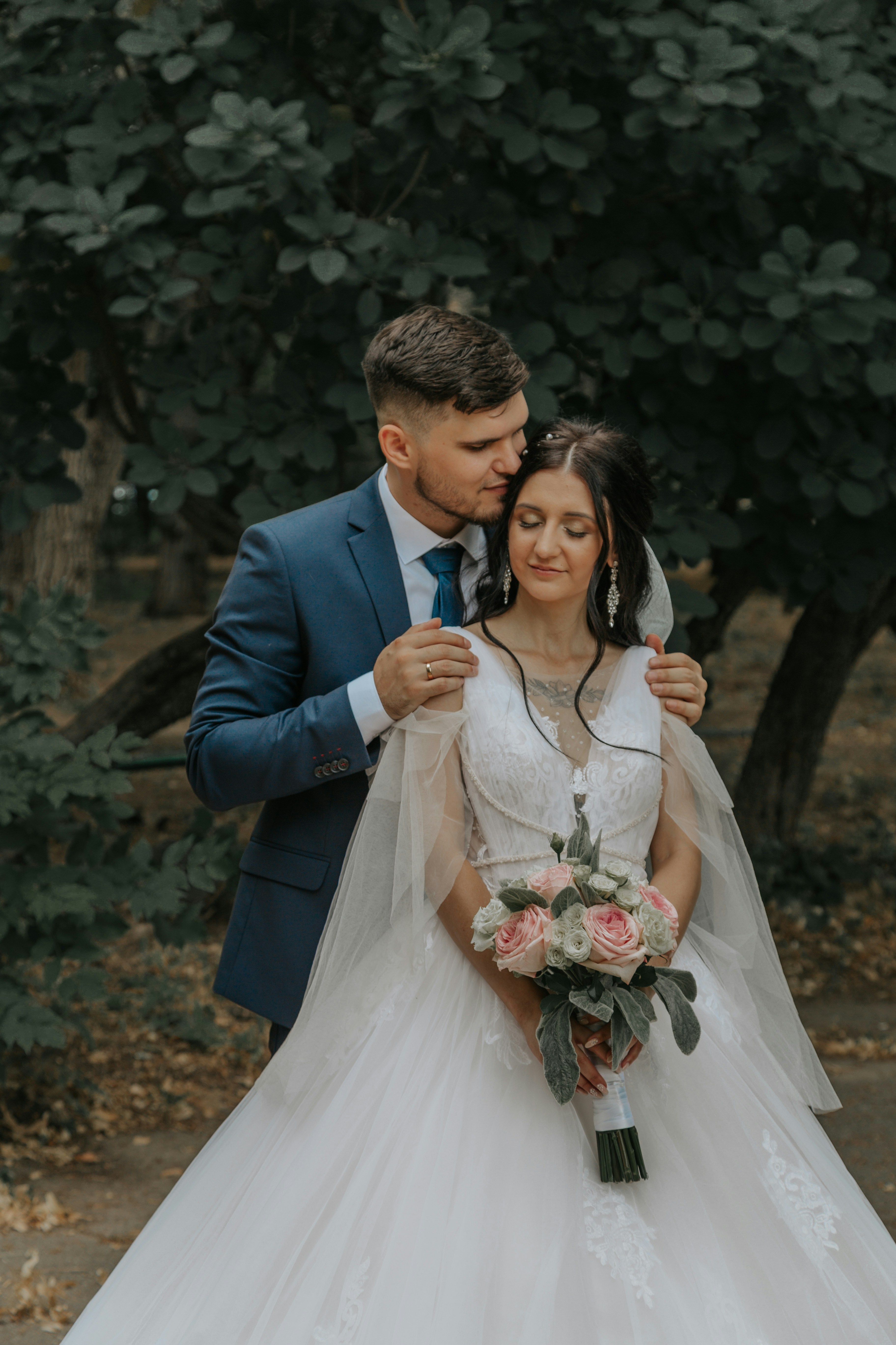 黒いスーツのジャケットを着た男性が白いウェディングドレスを着た女性