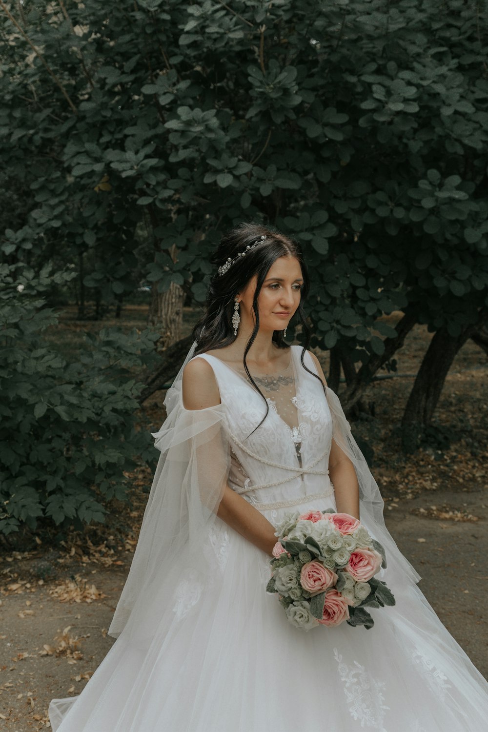 woman in white wedding dress holding bouquet of flowers