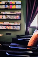 An inviting reading nook with eco-conscious books stacked on a natural wood shelf.
