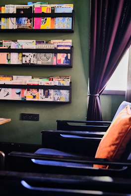 A spacious living room with an olive green built-in shelving system framing a cozy reading nook.