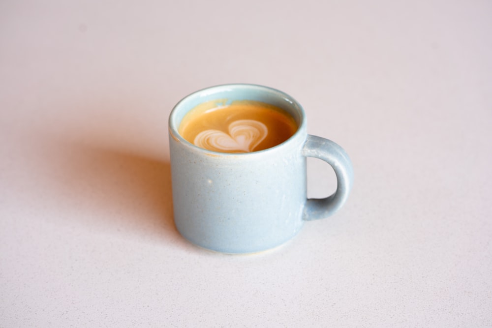 white ceramic mug with brown liquid