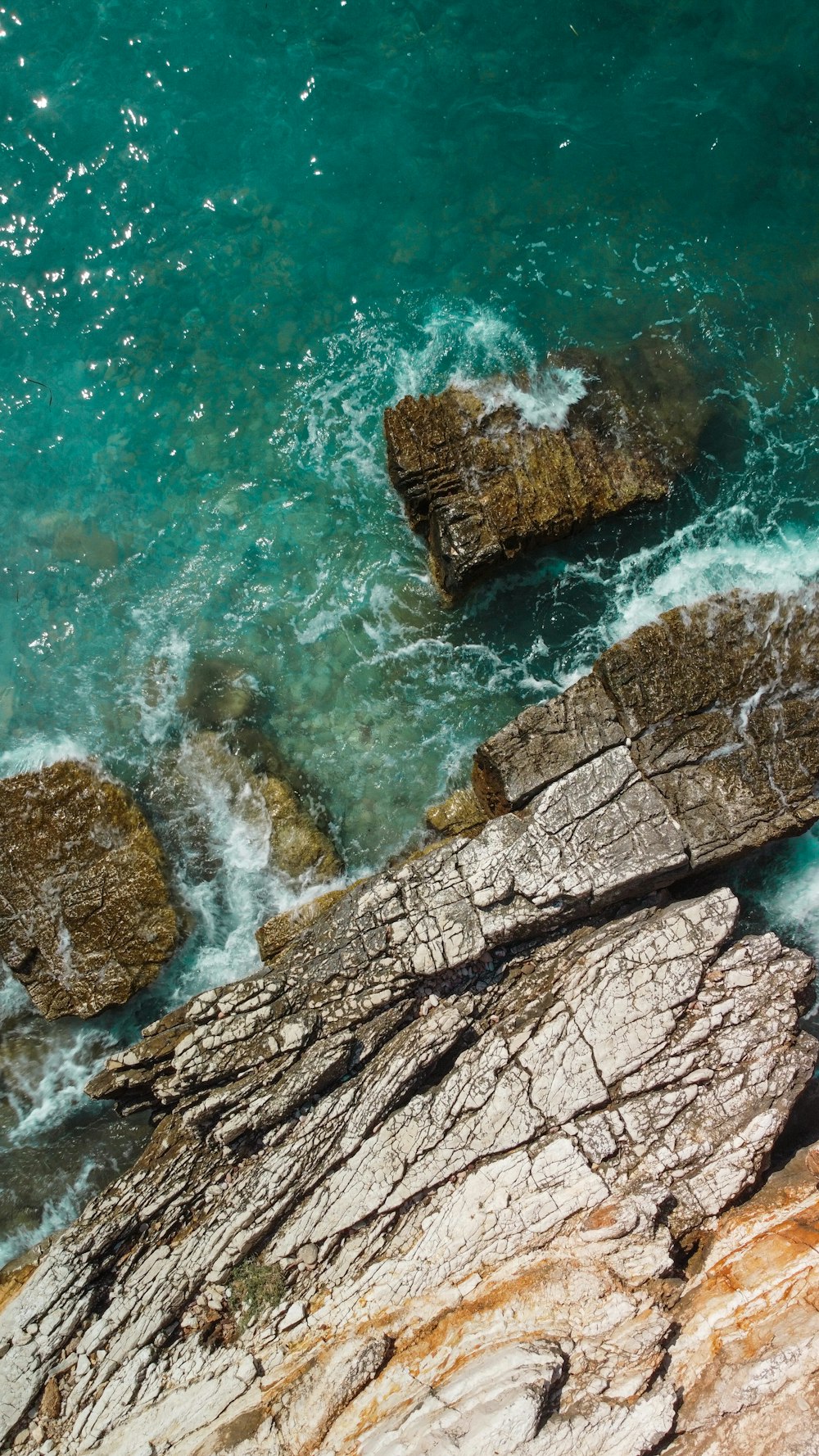 brown rock formation on body of water during daytime