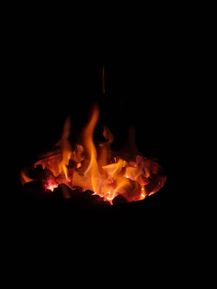 A warm, glowing fire burning brightly against a dark night sky, symbolizing generational faith and hope.