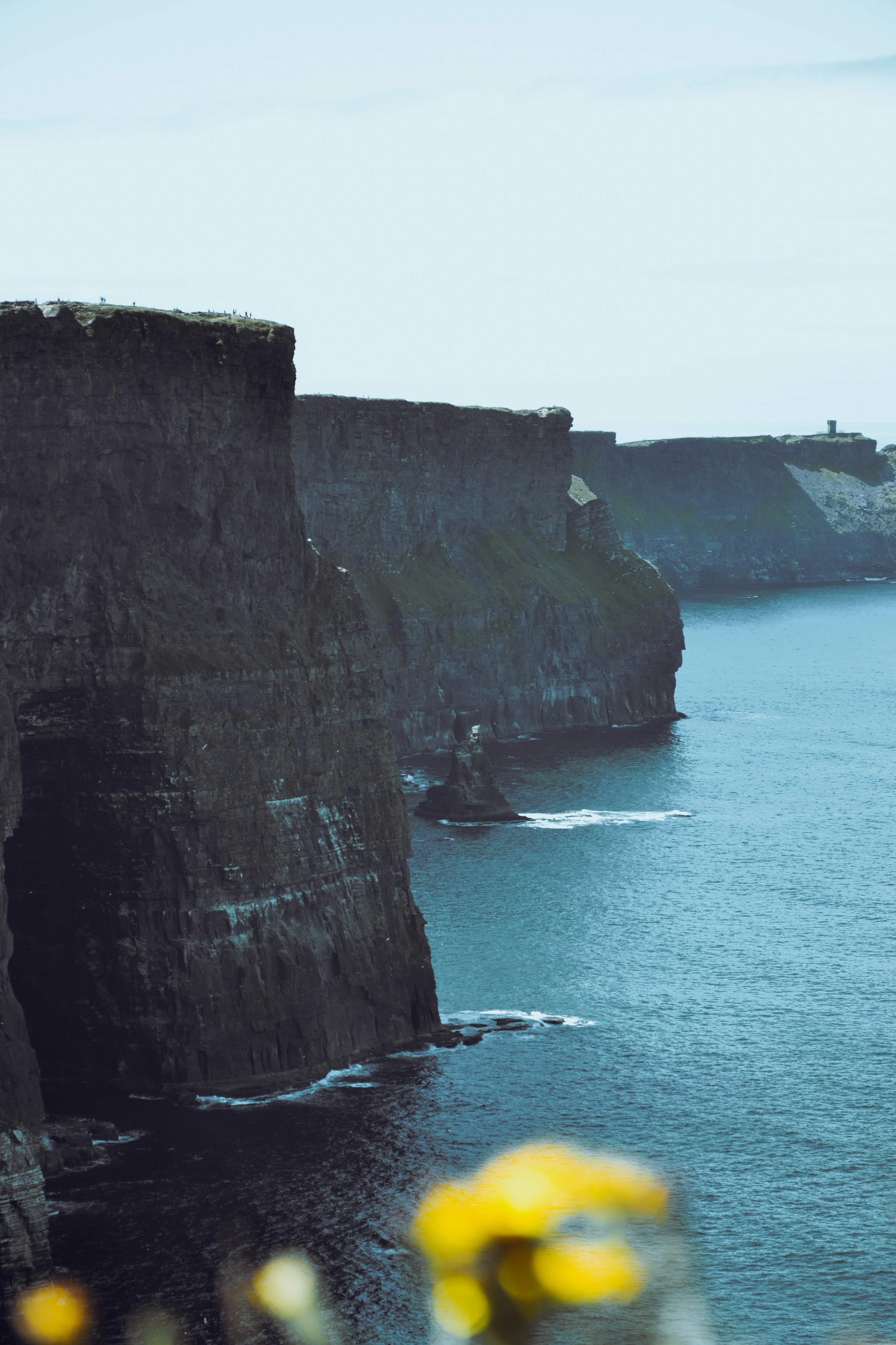 body of water near cliff during daytime