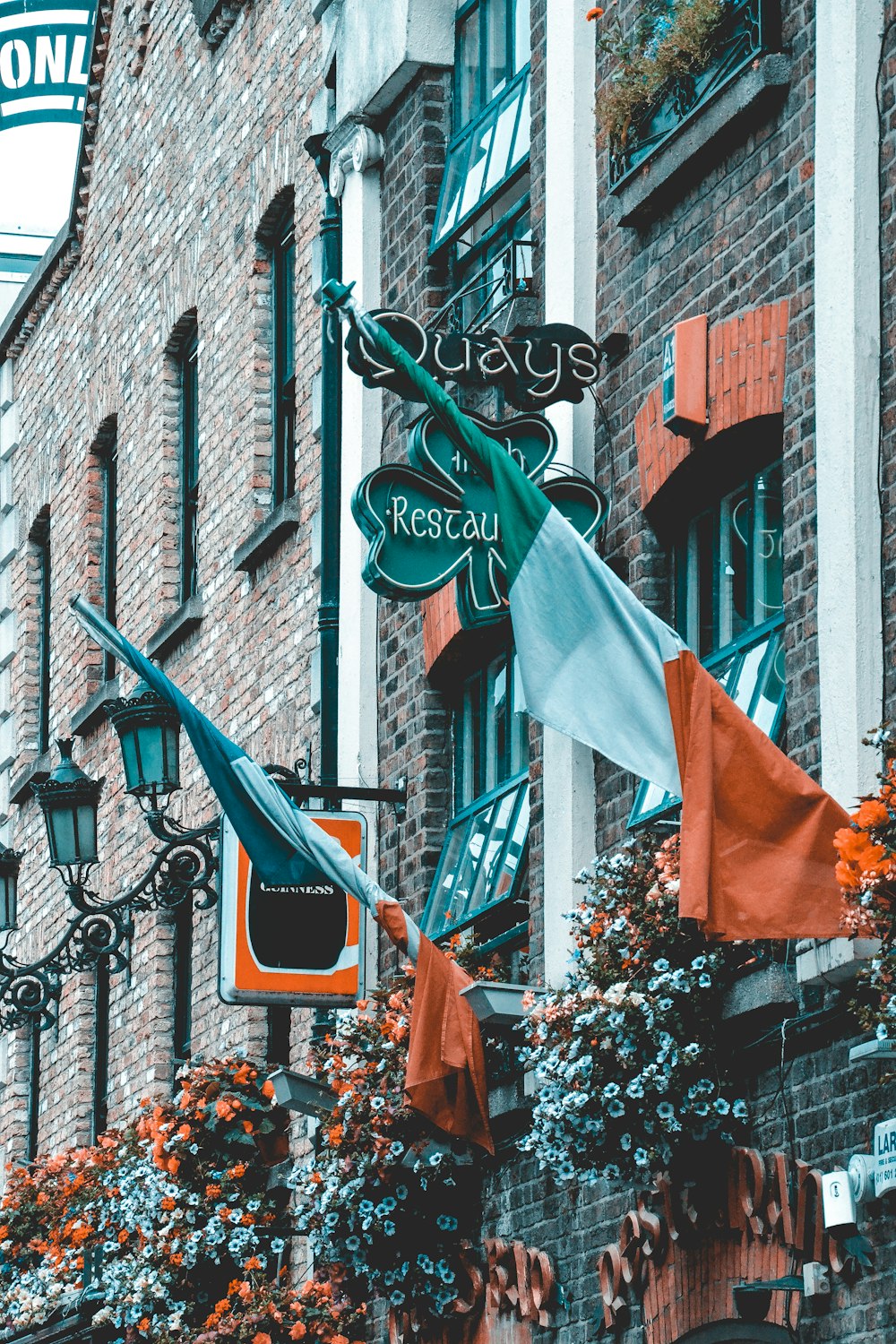 orange and green flags on black metal fence