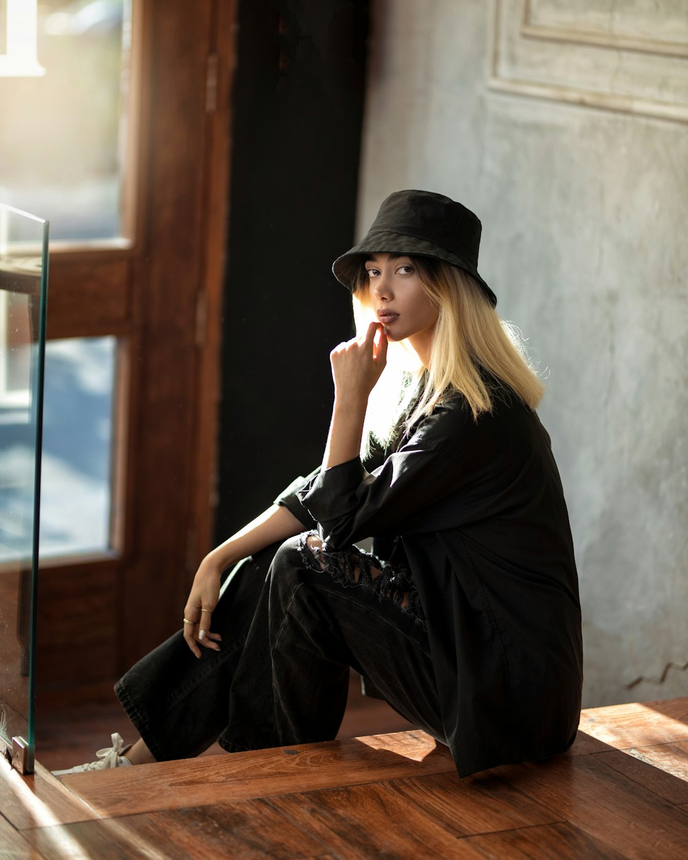 woman in black dress sitting on brown wooden bench