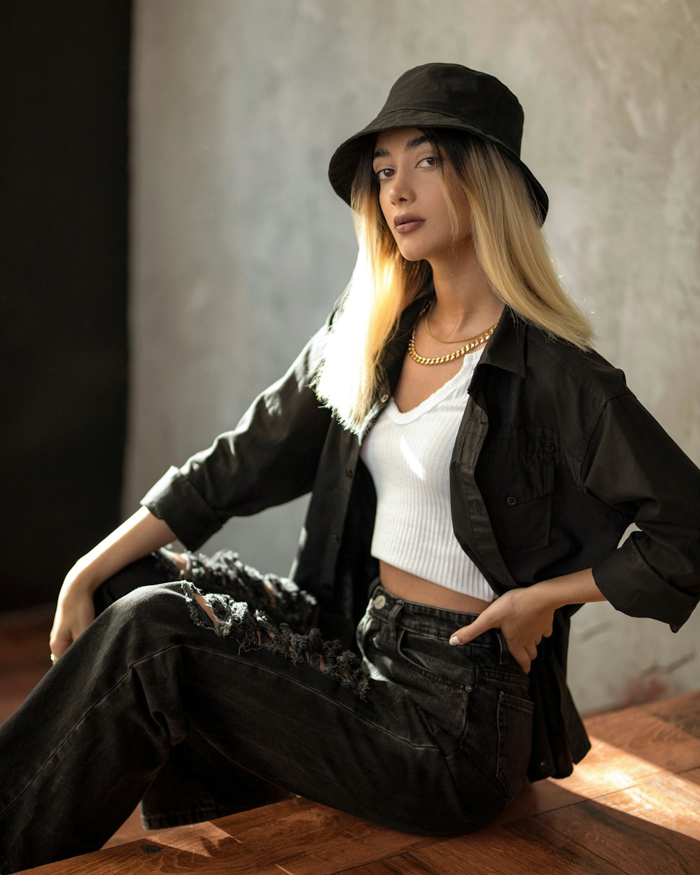 woman in black blazer and white shirt sitting on brown wooden bench