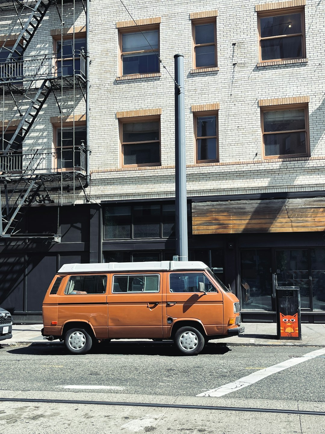 orange van parked in front of brown building