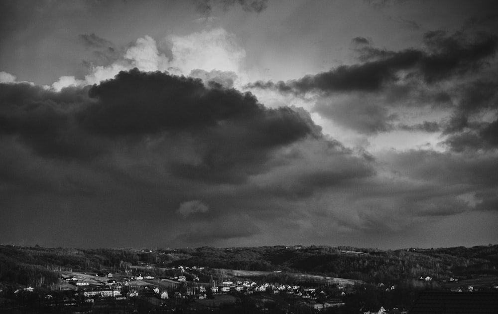 Graustufenfoto von Stadtgebäuden unter bewölktem Himmel