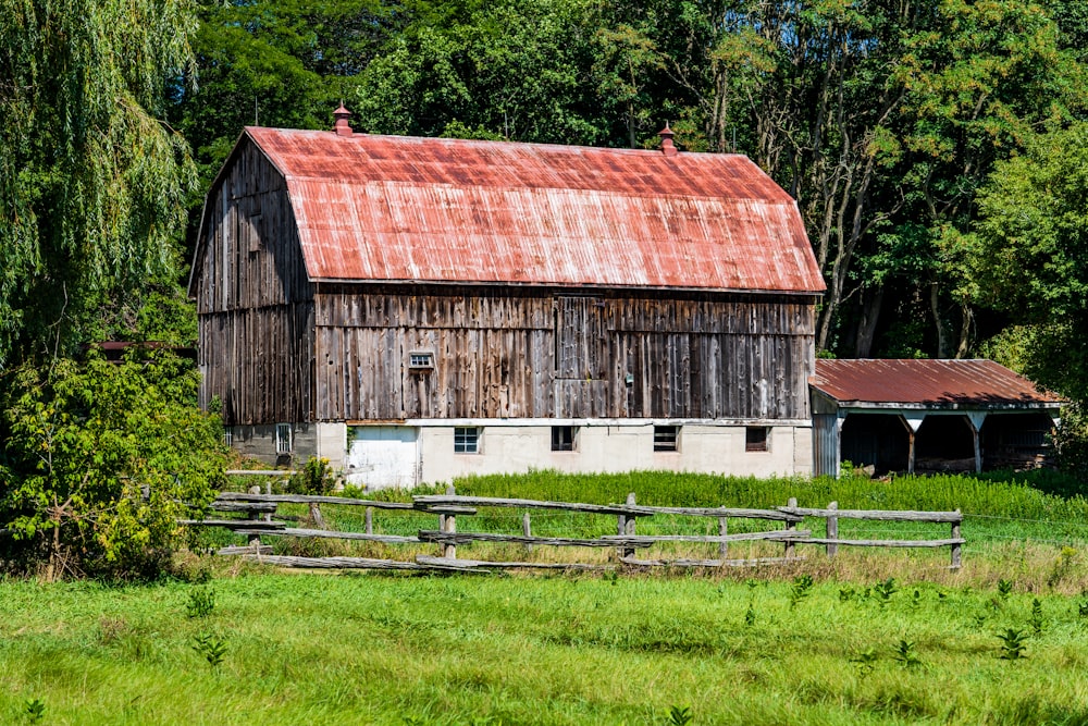 brown wooden barn on green grass field during daytime