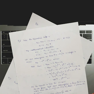 A student focused on solving advanced math problems with notes and a laptop nearby.