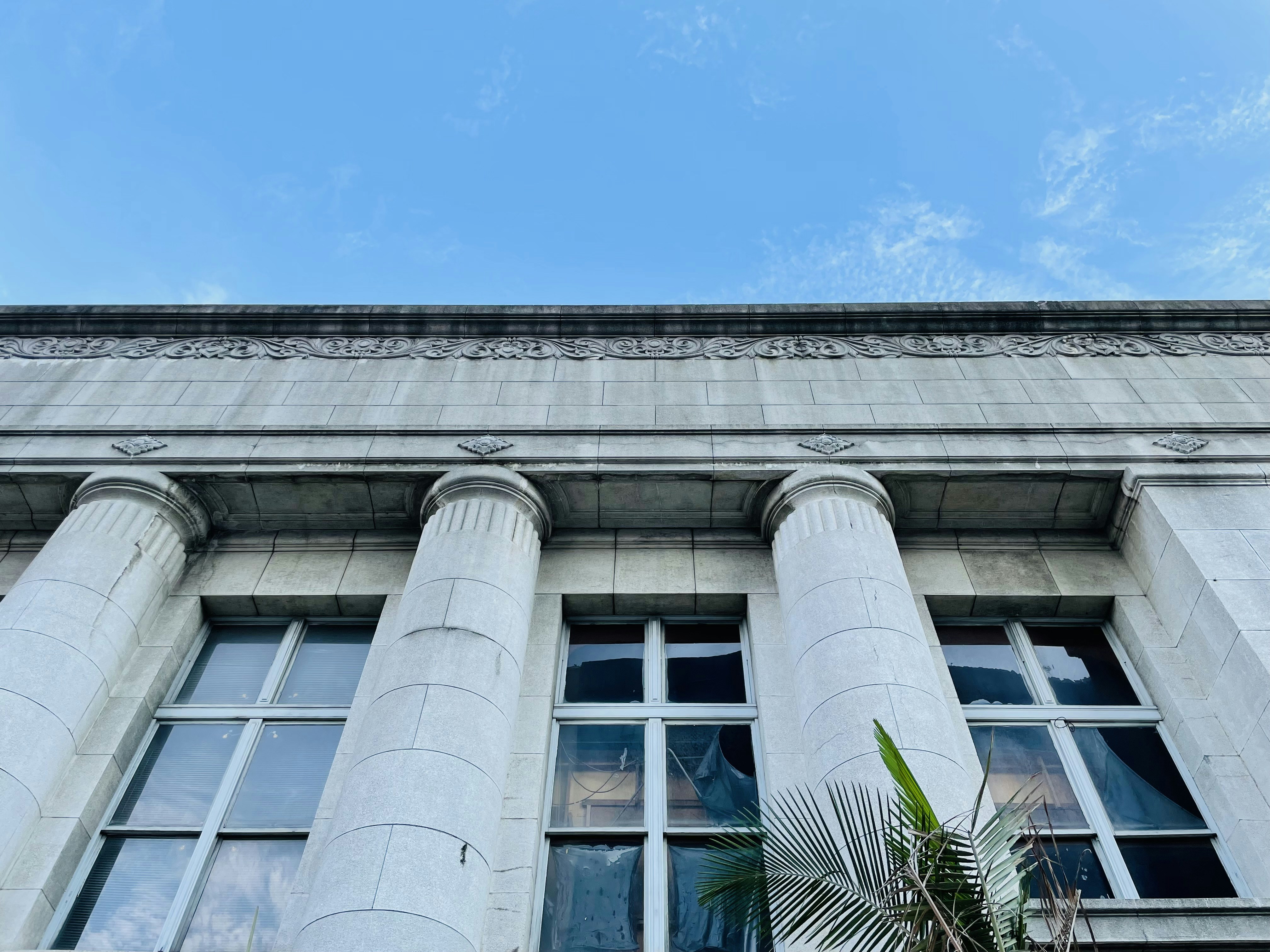 Weißes Betongebäude unter blauem Himmel tagsüber