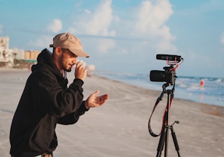 man in black jacket holding camera during daytime