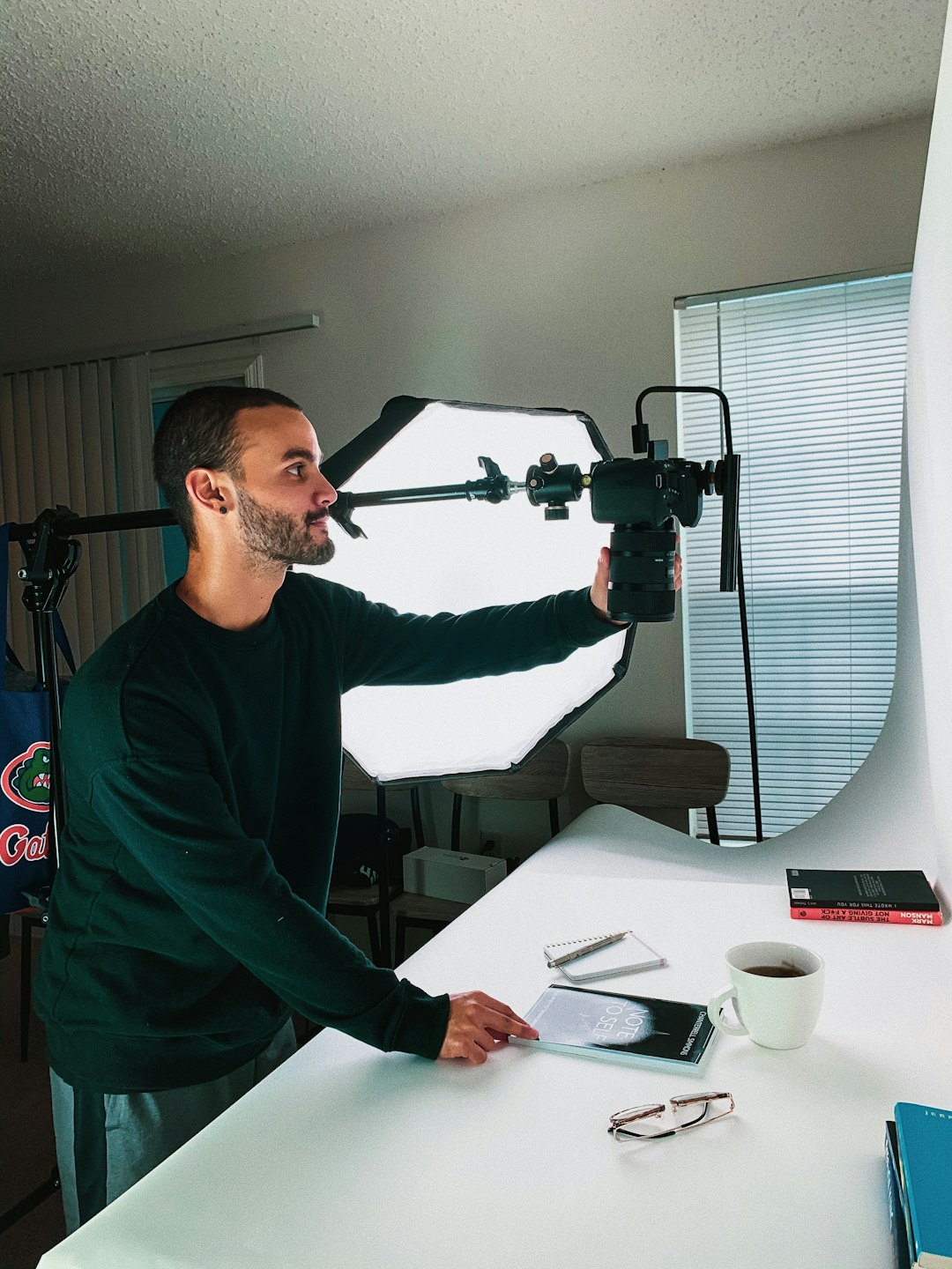 man in green sweater holding black and red power tool