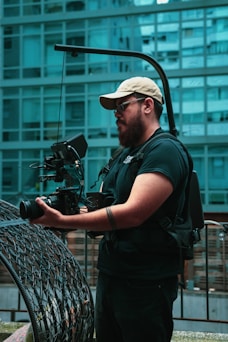 man in black t-shirt holding black dslr camera