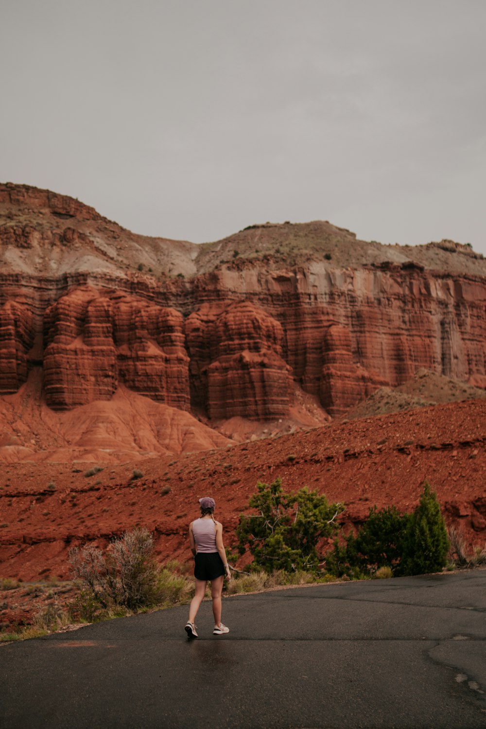 woman in white long sleeve shirt standing near brown rock formation during daytime