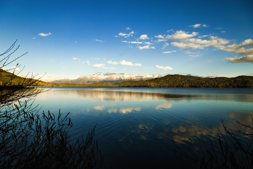 body of water near mountain under blue sky during daytime