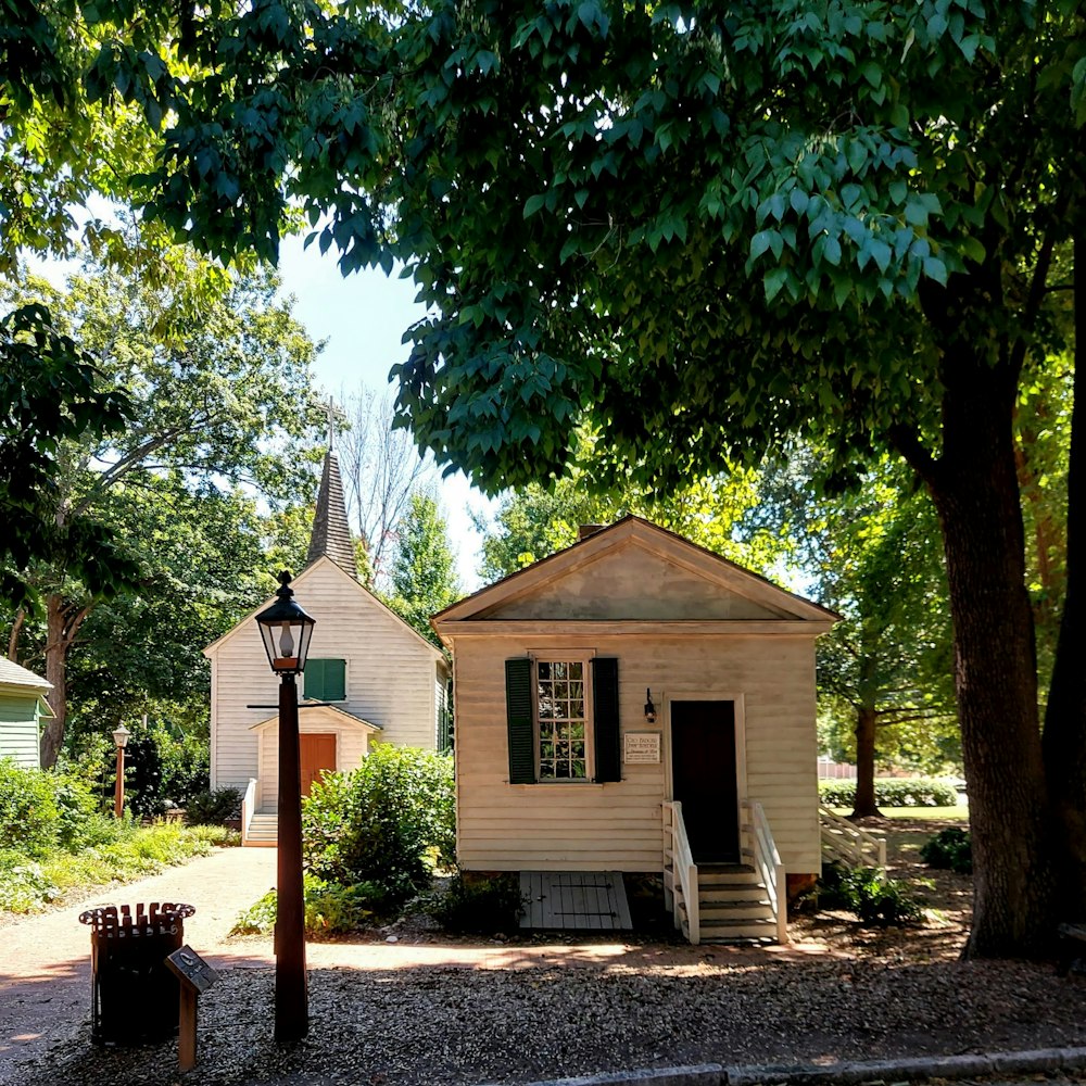 brown and white wooden house near green trees during daytime