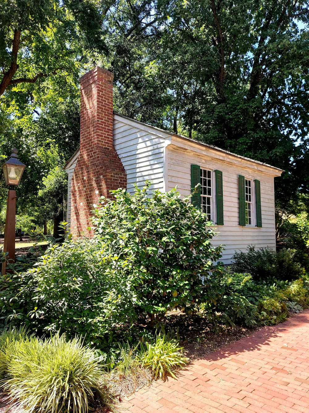 brown brick house near green trees during daytime