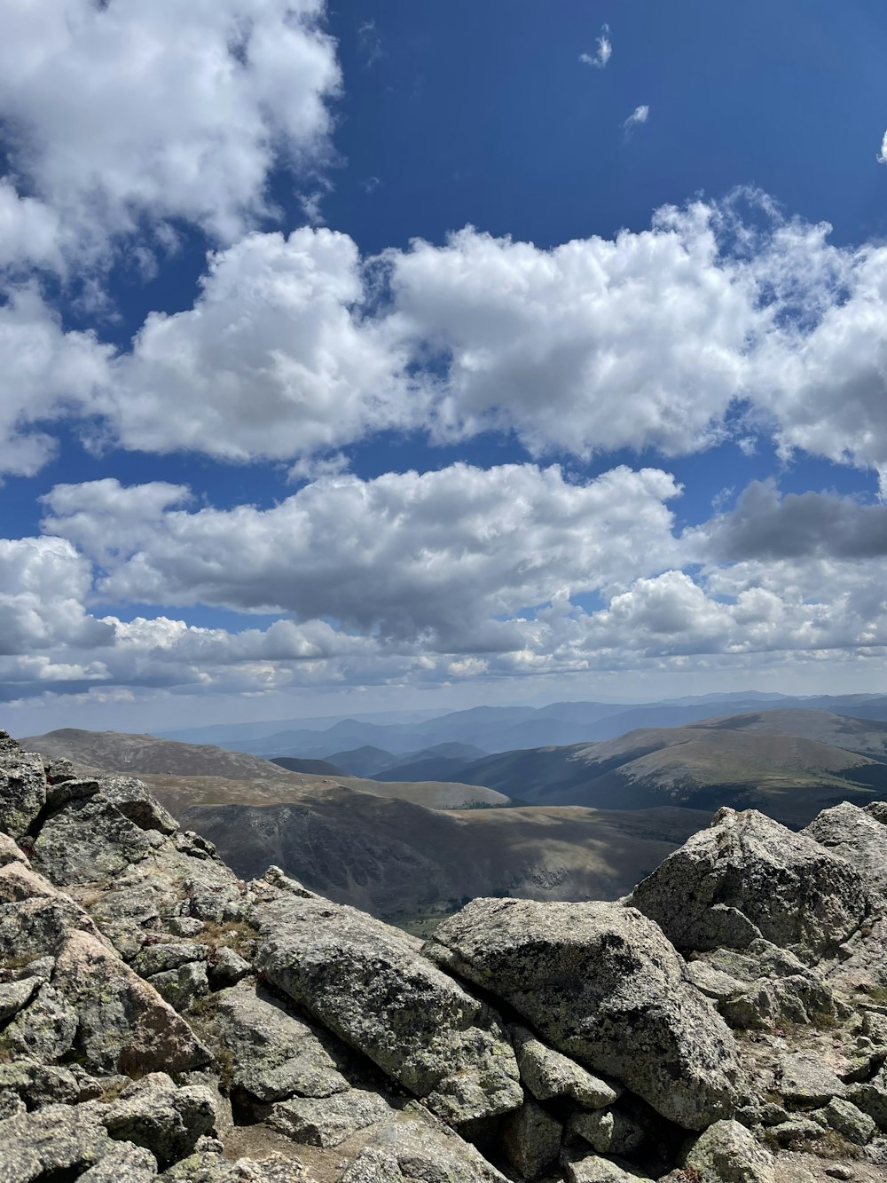 brown and gray mountains under blue sky and white clouds during daytime