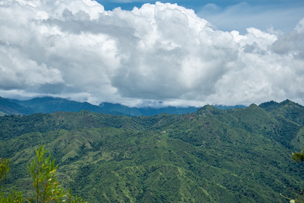 Grüner Berg unter weißen Wolken und blauem Himmel tagsüber