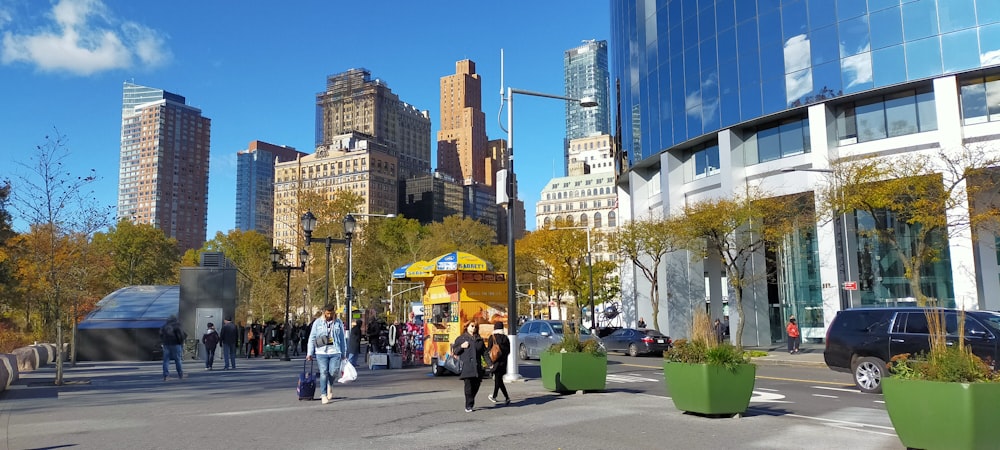 people walking on sidewalk near high rise buildings during daytime