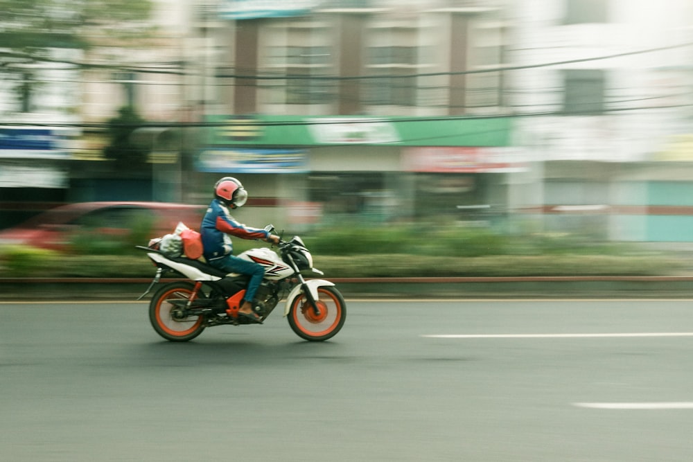 man in red and white motorcycle suit riding motorcycle