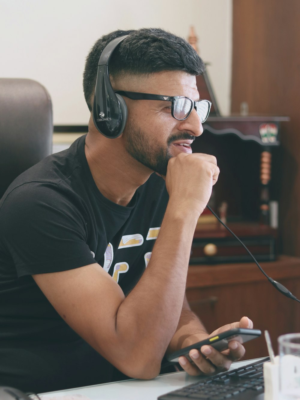 Hombre con camiseta negra de cuello redondo con gafas de montura negra