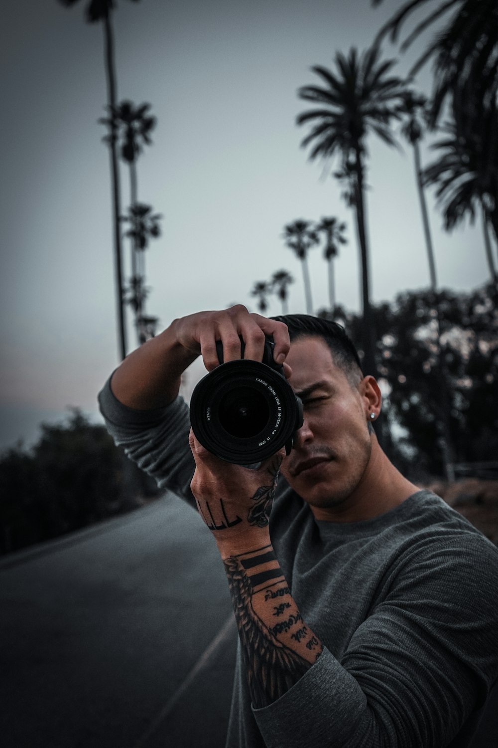 man in gray crew neck t-shirt holding black camera