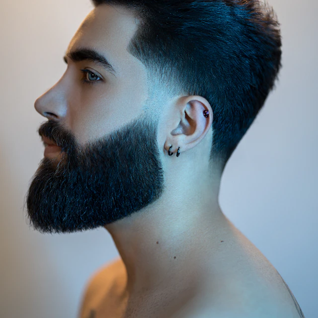 Profile view of a man with a thick beard and dark hair
