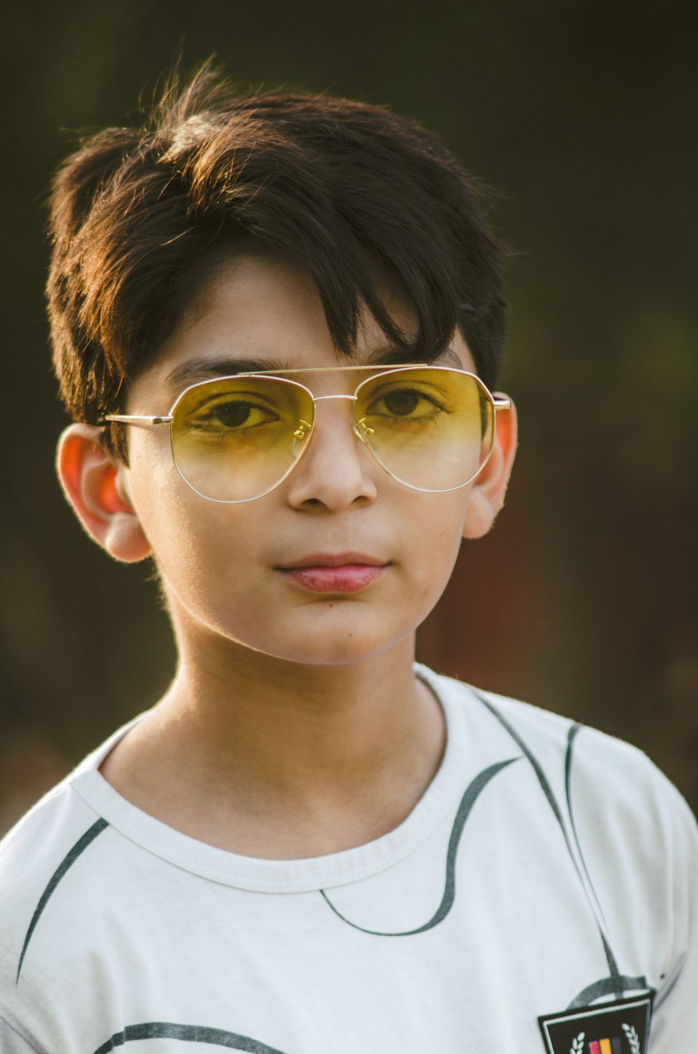 boy in white crew neck shirt wearing gold framed aviator sunglasses