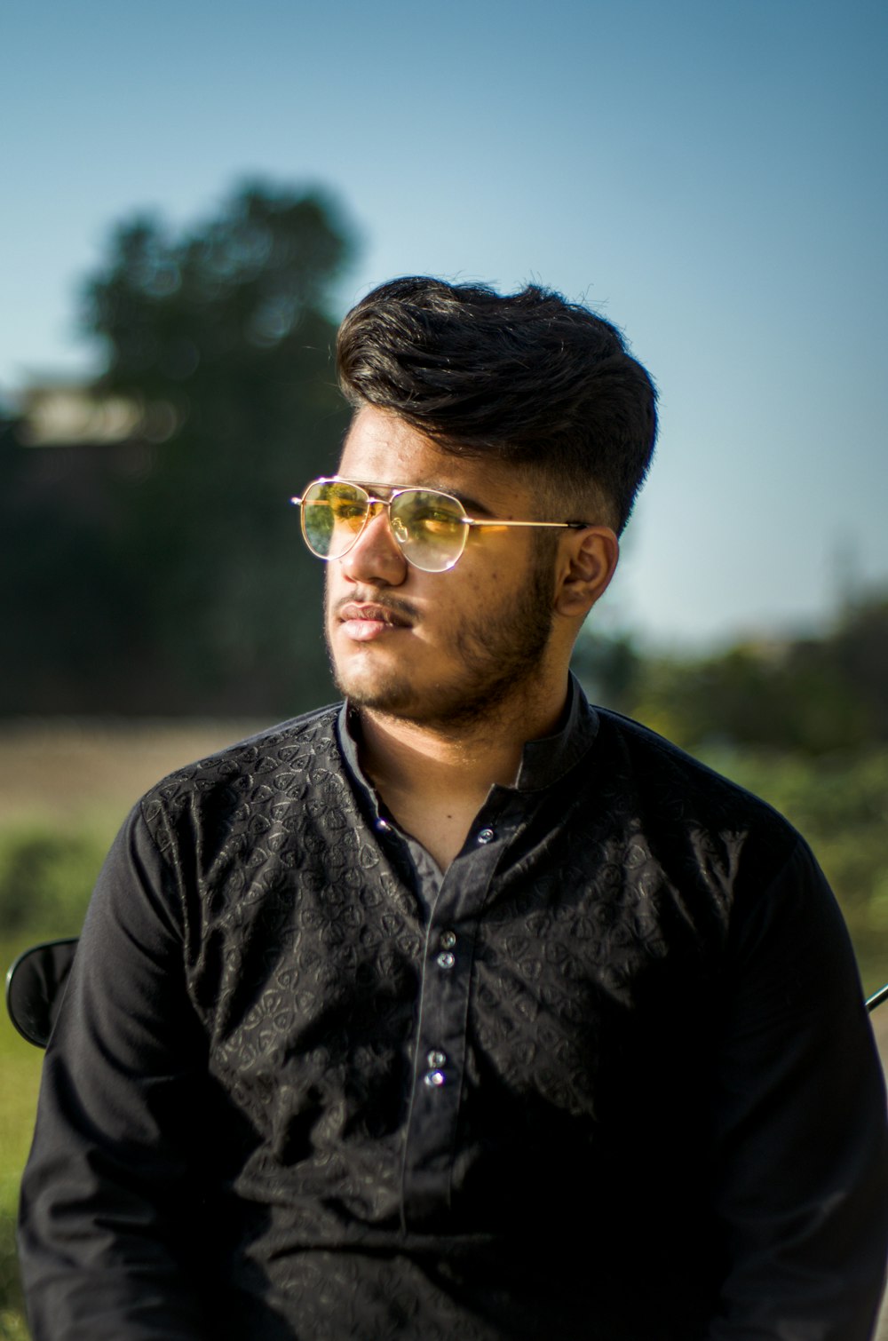principal Folleto Resplandor Foto Hombre con camisa negra abotonada y gafas de sol de aviador con montura  dorada – Imagen Pakistán gratis en Unsplash