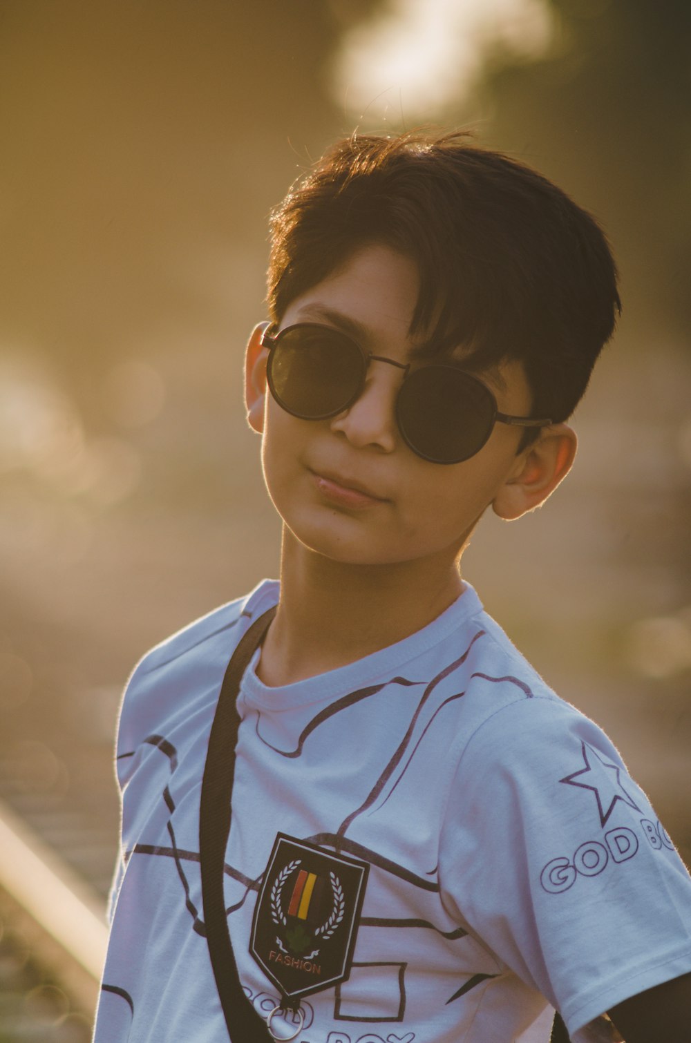 boy in white and blue crew neck shirt wearing black sunglasses