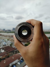 person holding black camera lens