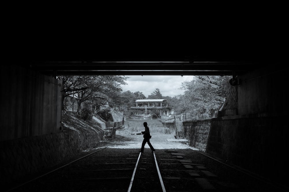 man in black jacket standing on gray concrete pathway during daytime