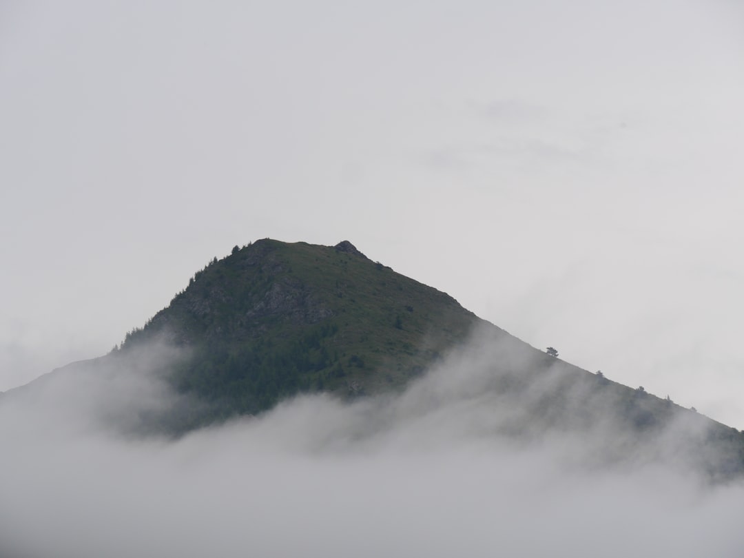 black mountain covered by white clouds