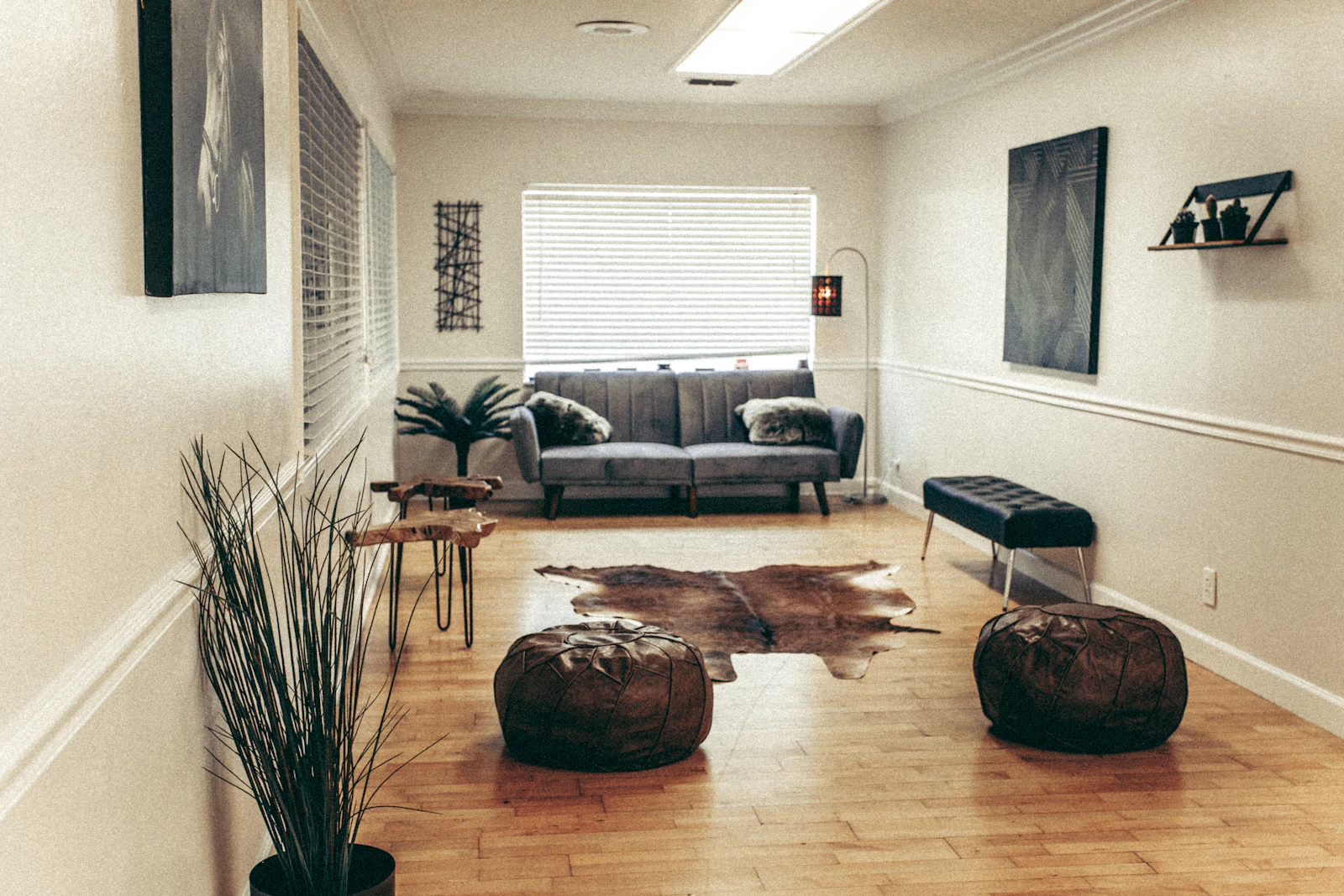A dark leather sofa beside a wooden coffee table in the reception area